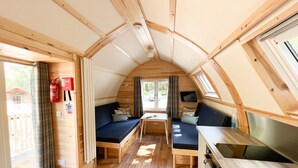 Een compact RV-interieur met een kitchenette, zithoek en een raam.