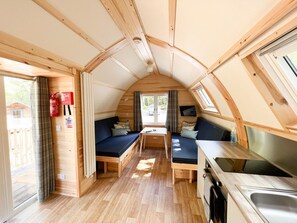 A compact RV interior with a kitchenette, seating area, and a window. - Woodland Lodge in the heart of Scotland (Tomintoul)