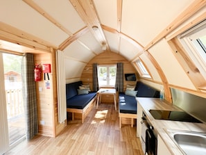 Interior compacto de una autocaravana con kitchenette, zona de estar y ventana.