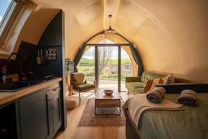 Un espace de vie confortable et compact comprenant une cuisine, un coin repas et un lit.