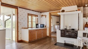 A kitchen with wooden cabinets, a stove, and a microwave. - Måbäcken by Interhome (Torestorp)