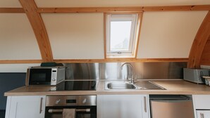 Een kleine keuken met een magnetron, broodrooster, spoelbak en vaatwasser.