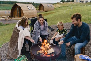 Eine Gruppe Menschen röstet Marshmallows am Lagerfeuer.