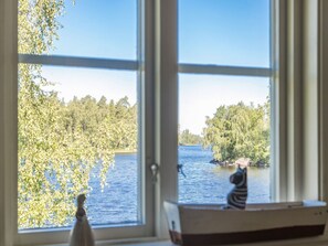 A view through a window with a wooden desk and a small figurine. - Lidelund by Interhome (Tingsryd)