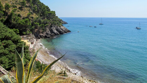 A coastal landscape with a rocky beach, clear blue sea, and boats. - Casa Belvedere by Interhome (Gaeta)