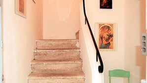 A staircase with a green chair at the bottom. - Casa Belvedere by Interhome (Gaeta)
