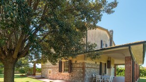 A stone building with a covered patio and outdoor seating.