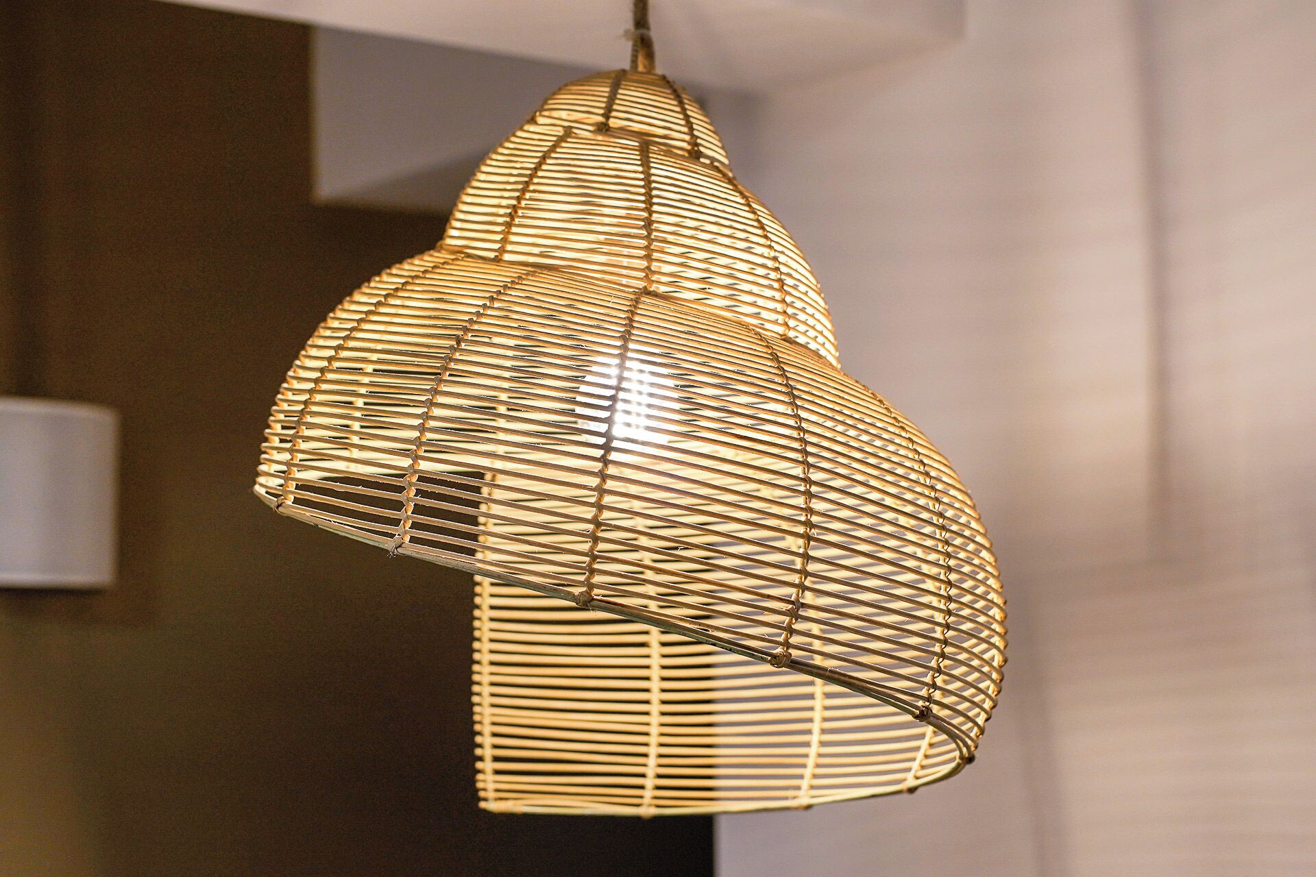 A hanging light fixture with a woven, geometric design.