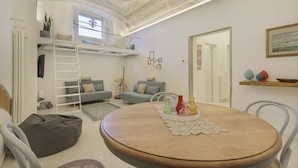 A room with a bunk bed, a round table with a tray, and a ceiling with intricate designs. - WelcHome Cellini Apartment (Firenze)