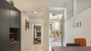 A modern interior with a dining area, a kitchen, and a view of the outside. - WelcHome Cellini Apartment (Firenze)