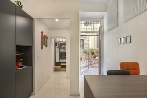 A modern interior with a dining area, a kitchen, and a view of the outside. - WelcHome Cellini Apartment (Firenze)