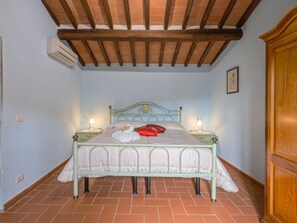 Un dormitorio con cama, lámparas de noche y un aire acondicionado.