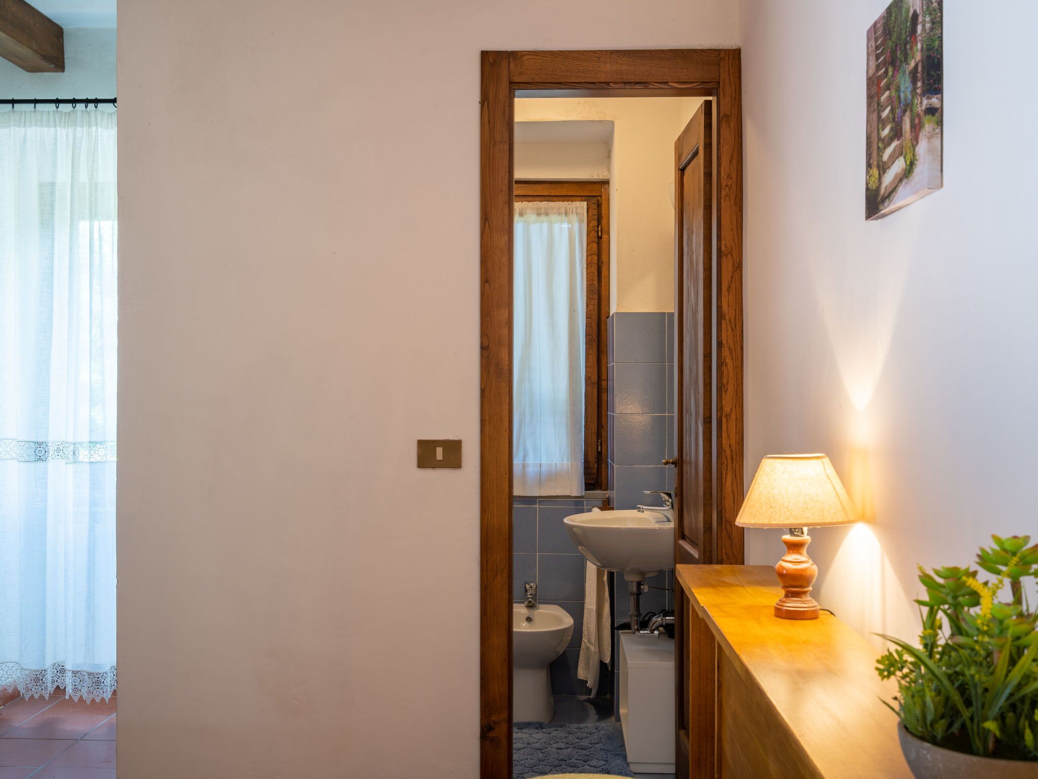 Une salle de bain avec une porte en bois, un lavabo, un bidet et un miroir.