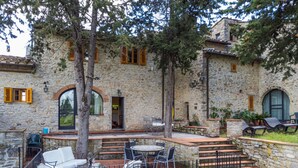 A stone building with outdoor seating and a staircase leading to an upper level. - San Rocco by Interhome (Greve in Chianti)