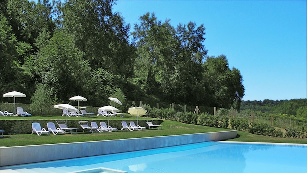 En swimmingpool med liggestole og parasoller.