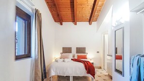 A bedroom with a bed, bedside tables, a window, and a mirror.