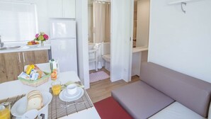 A compact room with a kitchenette, a dining area, and a seating area. - Camping Wien by Interhome (Peschiera del Garda)