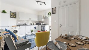 Un appartement moderne comprenant un coin repas, une cuisine et un espace de vie.