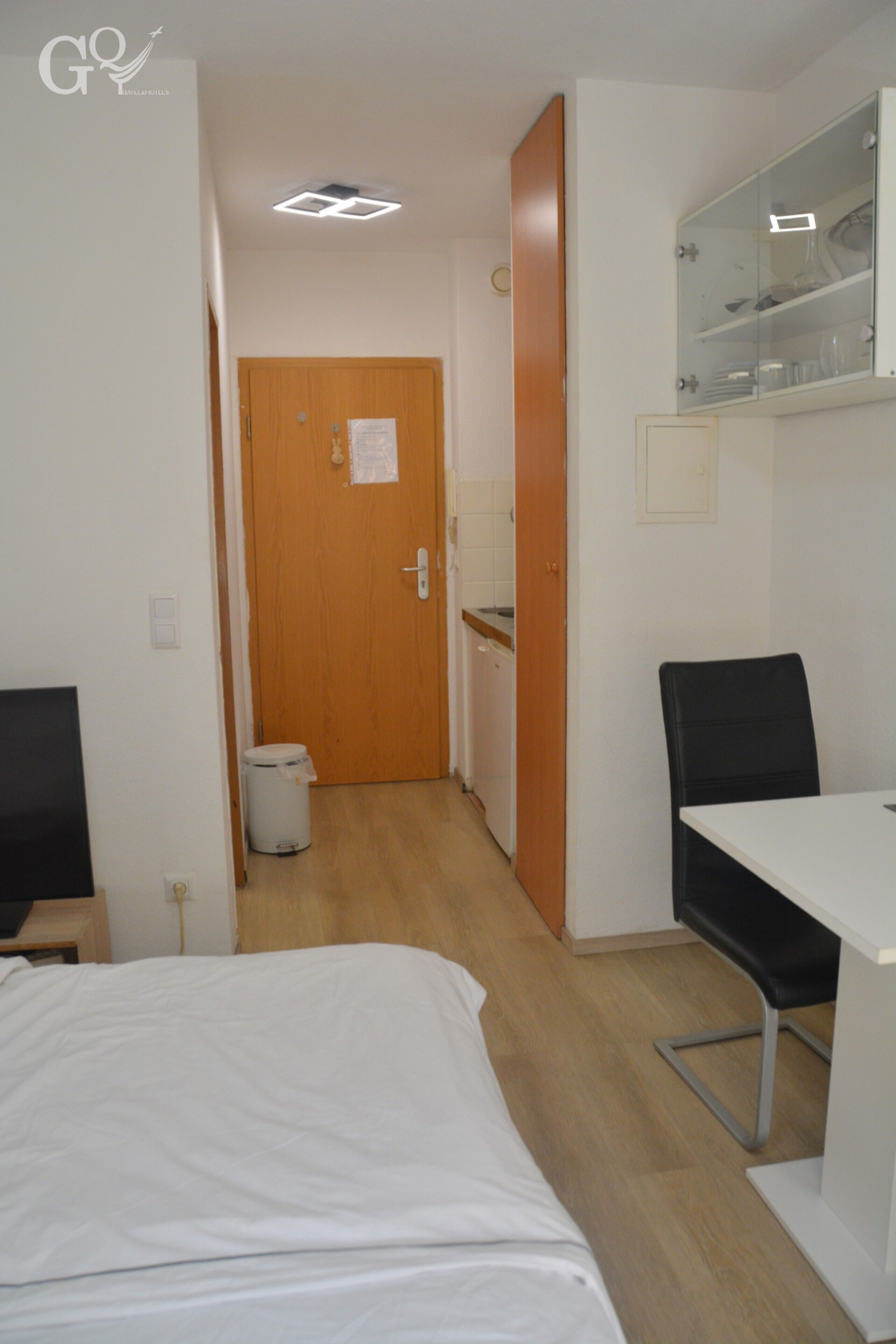 Een hotelkamer met een bed, een bureau, een stoel, een kledingkast en een badkamer.