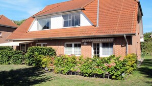 A two-story house with a red-tiled roof, white-framed windows, and a satellite dish. - Boddenbrise by Interhome (Waase)