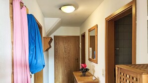 A hallway with wooden doors, a wooden bench, and a mirror on the wall. - Boddenbrise by Interhome (Waase)