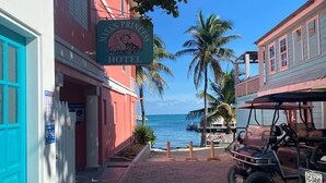 Un hotel llamado "Mapan Princess" con un letrero, un camino pavimentado y vista al océano.