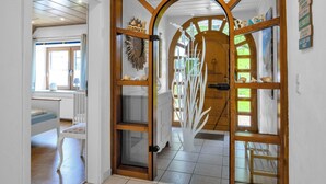 A wooden-framed door with a glass panel, leading to a room with a bed and a window. - Deichhaus Küstenwind by Interhome (Fedderwardersiel)