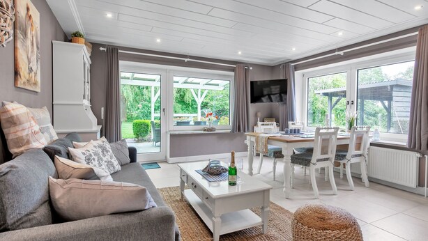 A modern living room with a sofa, coffee table, and dining area. - Deichhaus Küstenwind by Interhome (Fedderwardersiel)