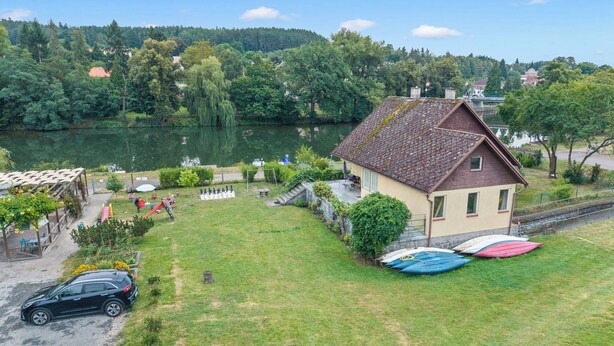 A house with a sloped roof, a small garden, and a view of a lake. - Lužnice by Interhome (Tyn nad Vltavou)