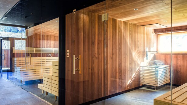 Ein modernes Interieur mit Holzvertäfelungen, einer Glastrennwand und einer Holzbank.