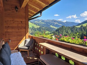 Ein Holzbalkon mit Blick auf eine Berglandschaft.