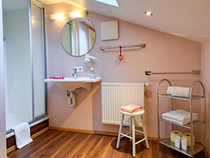 A bathroom with a sink, mirror, towel rack, radiator, and a stool. - Wegscheider by Interhome (Mayrhofen)