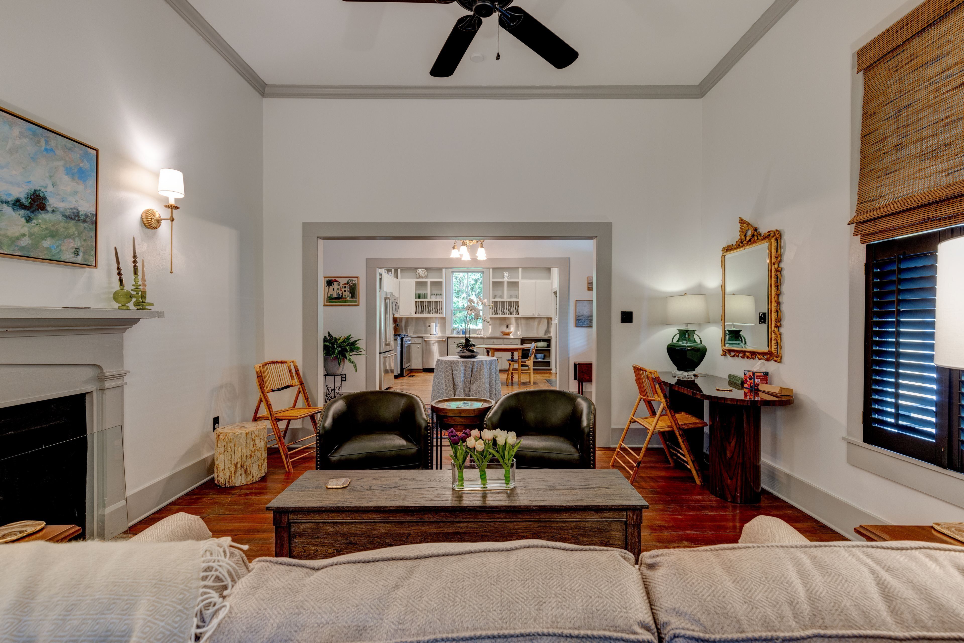 A living room with a fireplace, a dining area, and a kitchen visible through an open door.