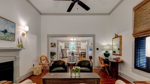 Una sala de estar con chimenea, un comedor y una cocina a la vista a través de un umbral abierto.