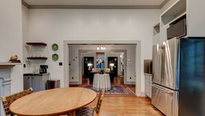 Una cocina moderna con refrigerador de acero inoxidable, mesa de comedor de madera y sillas. Hay una pequeña isla con pileta y encimera.