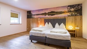Un letto matrimoniale con testiera in legno e un comodino con una lampada.