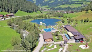 Ein Seeresort mit Schwimmbad, Restaurant und Blick auf die umliegenden Hügel.