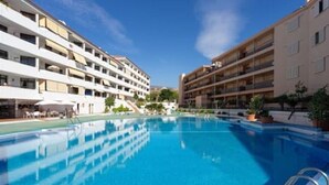 A swimming pool surrounded by multi-story buildings with balconies. - Home2Book Calm Ocean Los Cristianos (Los Cristianos)