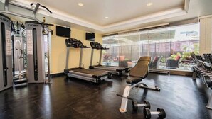 Una palestra con macchinari cardio, attrezzature per l'allenamento con i pesi e un'ampia finestra vista esterna.