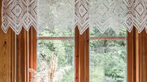 A room with a wooden window, a vase with dried plants, and a grey sofa. - Kasen Sjökanten by Interhome (Färgelanda)