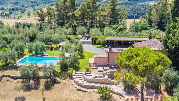 Ein Wohnhaus mit Schwimmbad, Sitzgelegenheit im Freien und Blick auf die umliegende Landschaft.