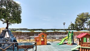A playground with climbing structures, slides, and small playhouses. - Riviera 10 by Interhome (Cecina)