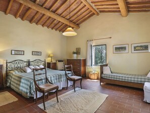 Une chambre confortable avec deux lits, un plafond en bois et une fenêtre donnant sur un paysage verdoyant.