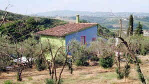 A small, single-story building with a tiled roof, surrounded by trees and hills in the background. - Conte Francesco II by Interhome (Certaldo)