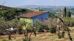 A small, single-story building with a tiled roof, surrounded by trees and hills in the background. - Conte Francesco II by Interhome (Certaldo)