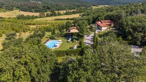 Un complex turístic amb piscina, habitacions i vistes al bosc i les colines circumdants.
