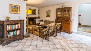 A cozy living room with a fireplace, a wooden cabinet, a sofa set, and a bookshelf. - San Lazzaro by Interhome (Monsummano Terme)
