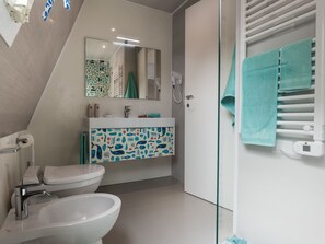 A bathroom with a toilet, bidet, and a shower area. - Marina Azzurra Resort by Interhome (Lignano Riviera)