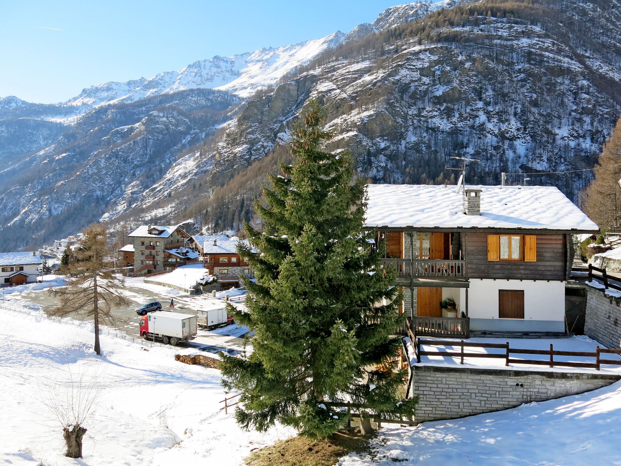 Eine Berglodge mit Holzausbau, einem Steinfundament und einem Balkon.