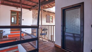 A wooden staircase leading to a balcony with a glass door.